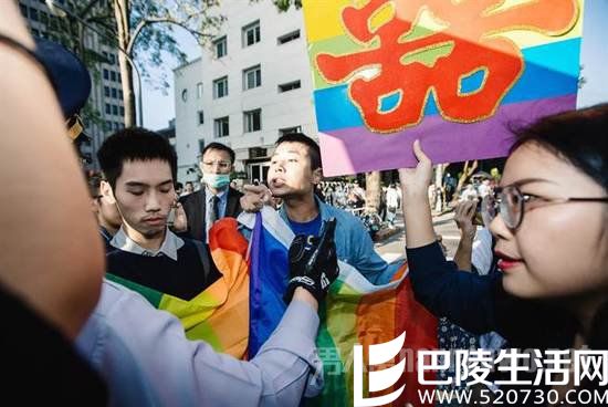 支持同性恋合法化的民众手举“喜”字，并拿着彩虹旗