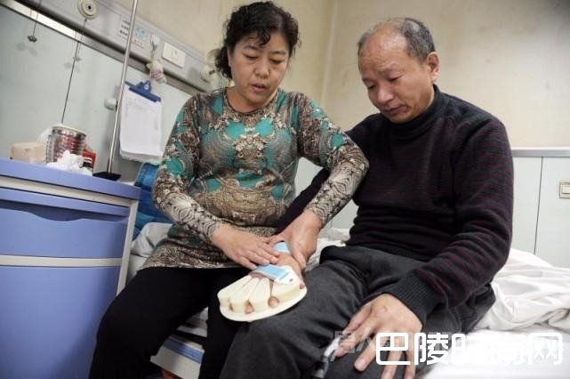 王菊玲帮助李建利使用手托矫正器 王菊玲帮助李建利使用手托矫正器