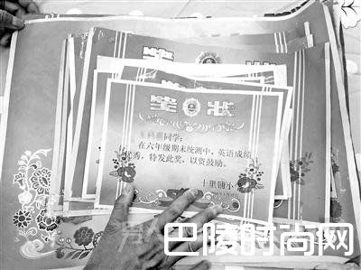 王泽涛手抚女儿蕾蕾历年来获得的奖状