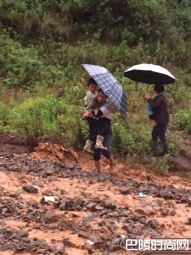 段瑞抱学生过涨水的河滩，鞋子已成了”泥鞋“。