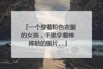 一个穿着粉色衣服的女孩，手里拿着棒棒糖的图片..